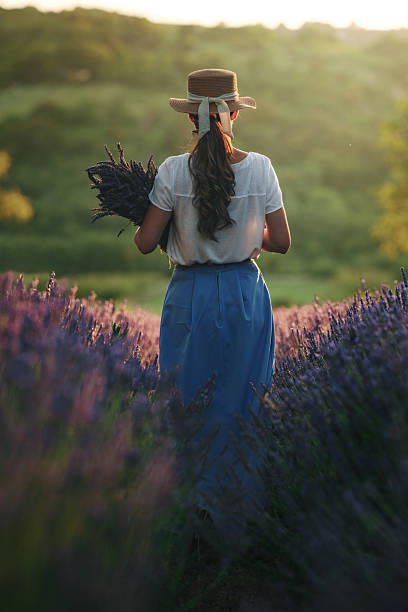 istock Woman walking through lavender field at sunset 2231984413