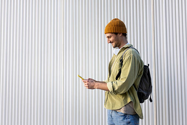 istock Smiling young man using smartphone in front of white background 2231984727