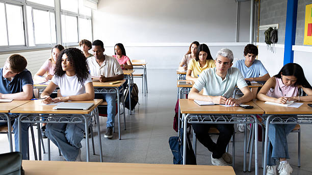 istock Multi-ethnic students taking exam in classroom at high school 2231986145