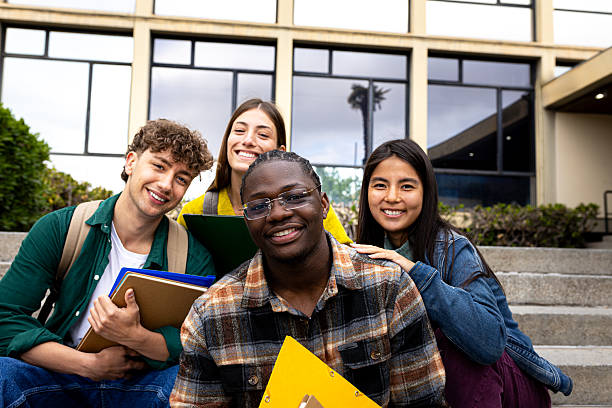 istock Cheerful university or college students smiling at camera outdoors 2231988175