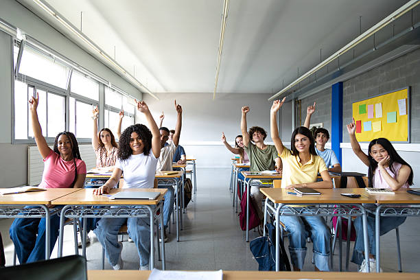 istock High school students raising hands in classroom 2231988197