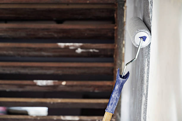 istock Construction worker using a paint roller to apply paint to a wall during home renovation. Home renovation project 2231988881