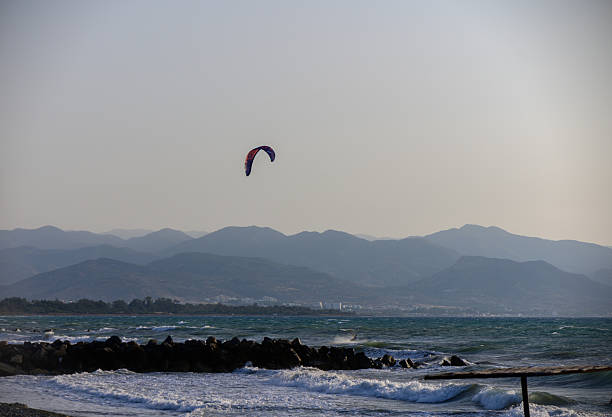 Kitesurfing scene with splashing waves and soft evening light.