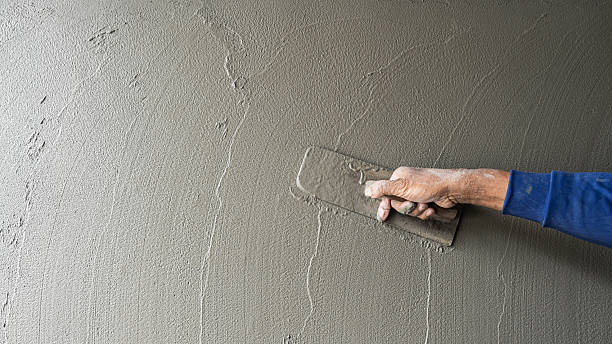 istock Hand plaster plastering Cement wall background with Rough wet concrete mortar plaster for polished building site wall holding trowel well banner free space texture for text 2231991589