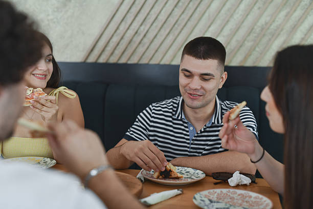 istock Friends Smiling And Sharing Fresh Pizza Together While Relaxing In Cozy Restaurant Setting 2231992226
