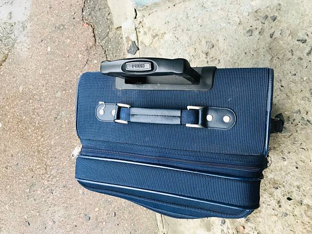 istock Travel suitcase resting on concrete surface near blue wall 2231992922