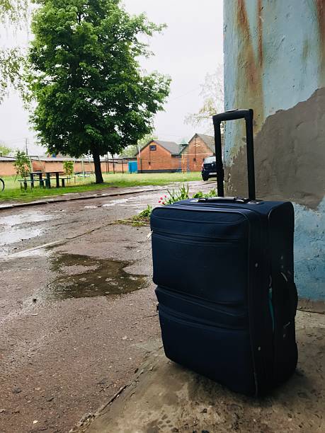 istock Travel suitcase resting against a weathered wall outside 2231992977