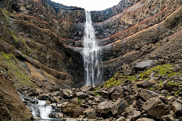 Hengifoss is one of Iceland’s tallest waterfalls, cascading over striking basalt cliffs with vivid red clay layers. Located in East Iceland, this unique geological site offers a dramatic and colorful display of volcanic history. Ideal for themes of nature, geology, and travel.