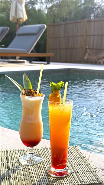 istock Tropical cocktails garnished with pineapple, mint, orange sitting poolside, representing summer leisure with vibrant refreshing colors and vacation mood 2231995702