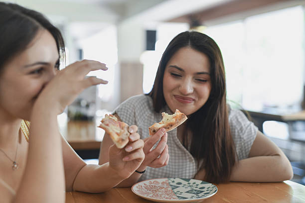 istock Joyful Female Friends Enjoying Pizza Date Smiling While Eating 2231996334