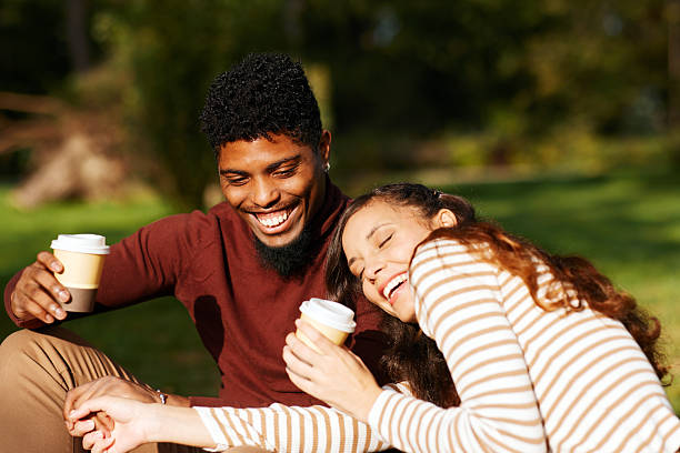 istock Happy multi-ethnic couple laughing and drinking coffee outdoors in autumn 2231996342