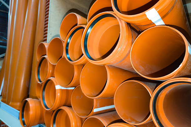 istock Piles of bright orange plastic pipes arranged in a warehouse ready for construction uses during the daytime 2231999938