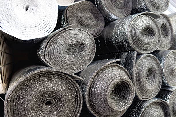 istock Rolls of black and silver insulation material stacked in a construction area ready for use in a new building project during daytime 2232000145