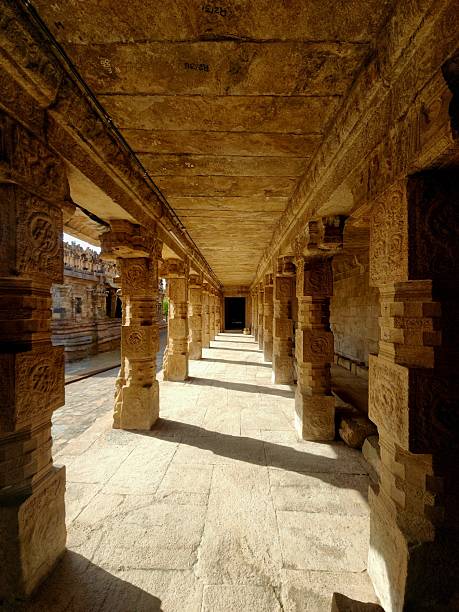 istock A stone-pillared corridor inside an ancient South Indian temple from Dharasuram, Tamilnadu, India, showcasing intricate carvings and symmetrical architecture with dramatic light and shadow 2232004879