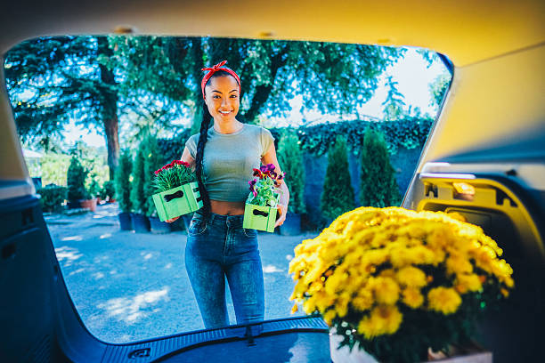 istock Female customer loading fresh flowers into car trunk 2232007396