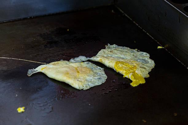 Cooked eggs lightly folded browned hot griddle traditional Taiwanese breakfast shop preparation