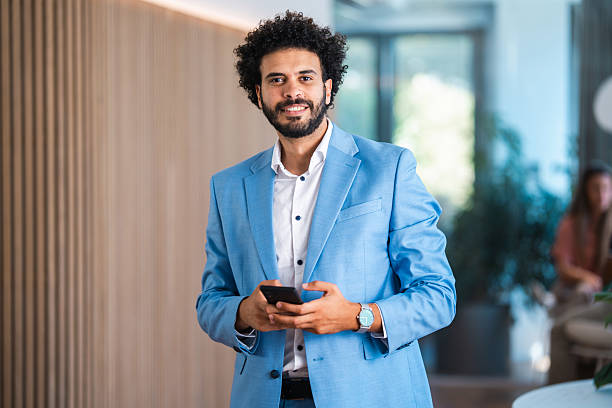 istock Confident Middle Eastern Businessman in Modern Office Holding Phone 2232008262