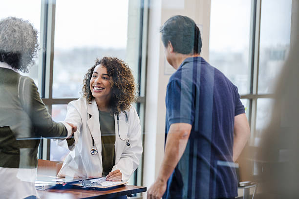 istock Confident female doctor shaking hands with patient 2232012286