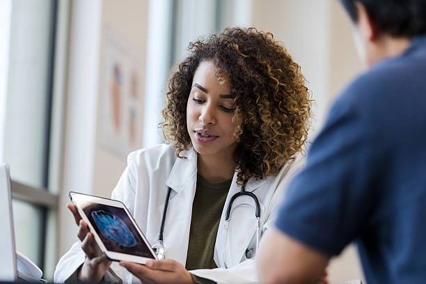 istock Doctor showing patient brain scan on digital tablet 2232012304