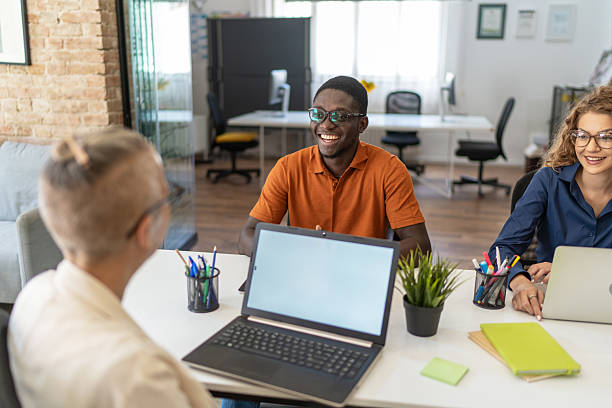 istock Young multiethnic businesspeople having a meeting using laptops in a modern office 2232013213