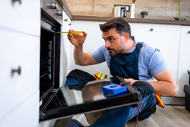 istock Man repairs oven while crouching on kitchen floor during afternoon 2232013810