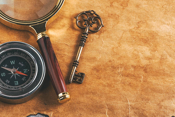 istock Vintage magnifying glass, compass and antique key on background old paper. 2232016210