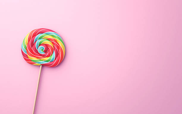 istock Multicolored Flavored Spiral Candy Lollipops on Pink Soft Background 2232017474