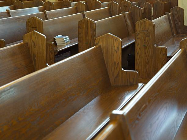 istock Stack of hymnals at the end of a pew 2232019427