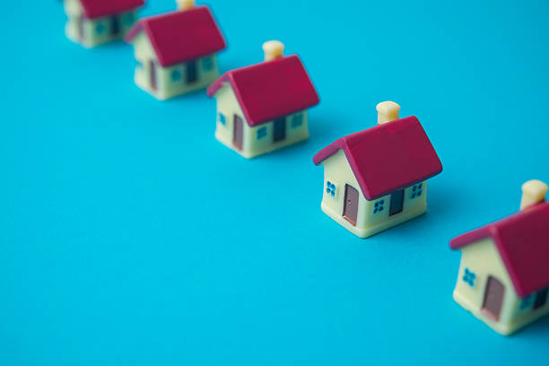istock Row of small houses on blue background copy space. 2232019794
