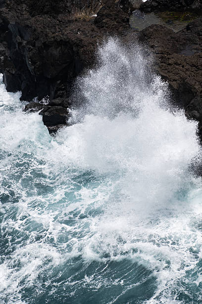 istock Big ocean wave crashing against rocky coast Vertical 2232021845