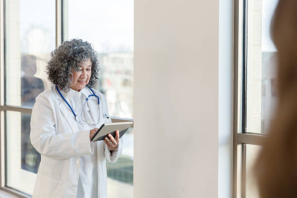 istock Mature Female Doctor Using Digital Tablet in Hospital 2232024459