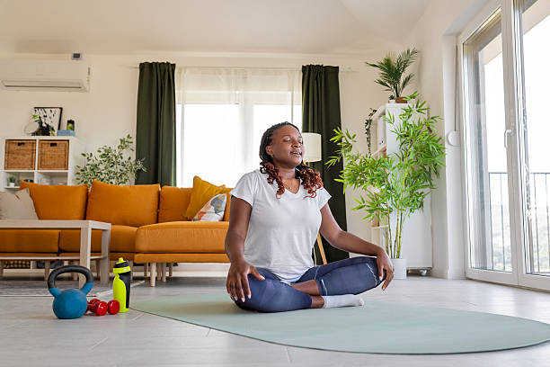 istock Beautiful woman practicing home yoga exercises in morning light 2232025609