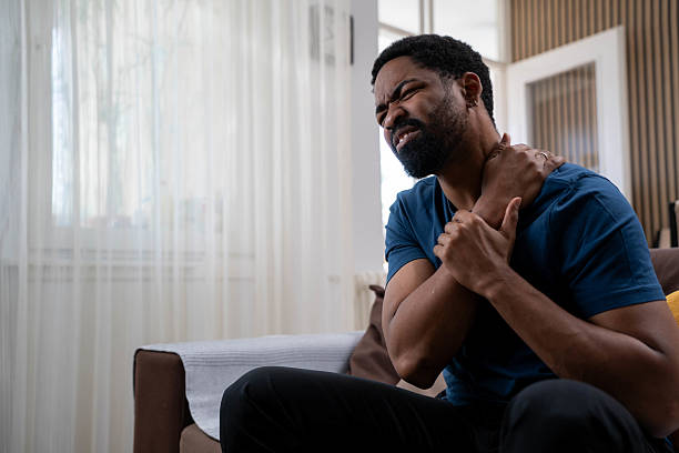 istock Unhappy man suffering from neck pain at home 2232027295
