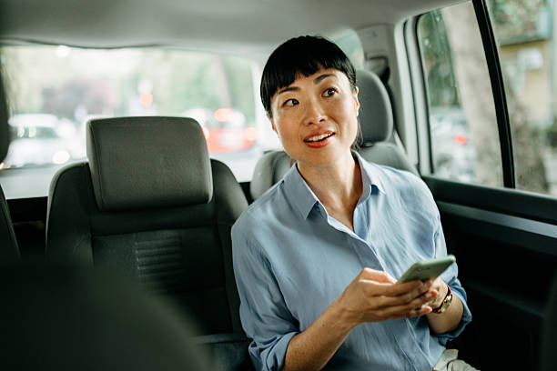 istock Businesswoman texting on smartphone while riding in car 2232038740