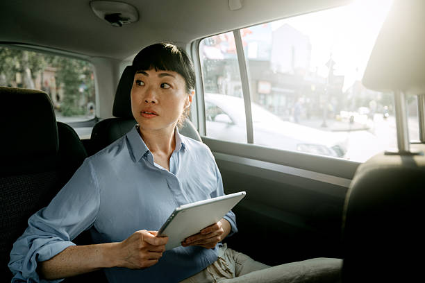 istock Well dressed businesswoman using digital tablet while riding in car 2232038774