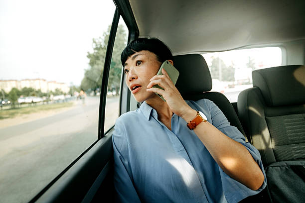 istock Businesswoman talking on smartphone while riding in car 2232038810