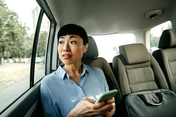istock Businesswoman texting on smartphone while riding in car 2232038823