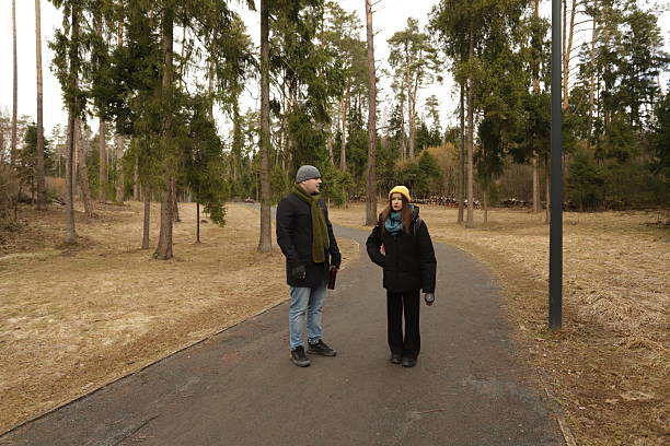 istock Couple walking and talking in winter forest park 2232040632