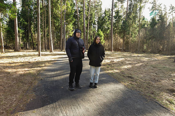 istock Two people enjoying peaceful time outdoors, walking in pine forest with hands in pockets and light smiles, embracing fresh air, mindfulness, and seasonal connection. 2232040735