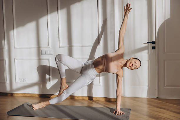 istock Woman practicing yoga side plank pose variation at home 2232041561