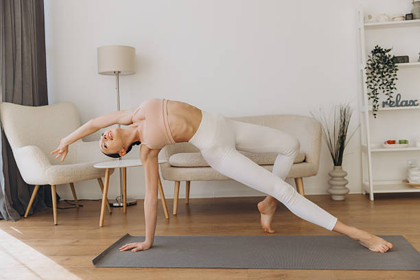 istock Young woman practicing yoga side plank pose at home 2232041986