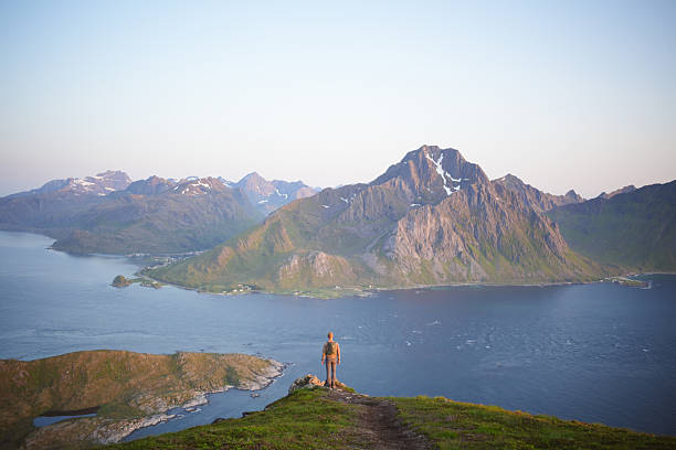istock Young man on viewpoint above calm bay and islands at sunrise 2232045444