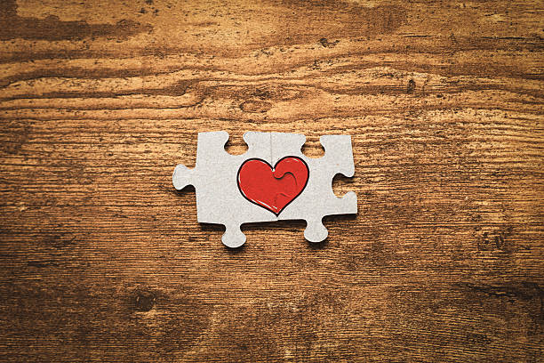 istock Two puzzle pieces with a heart as a symbol of relationship. 2232053843