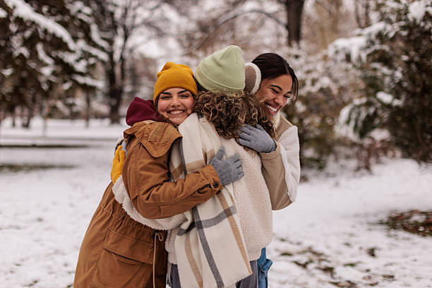 istock Female friends hugging in snowy park 2232054025