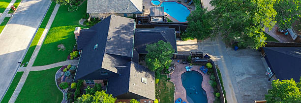 Panorama aerial view multiple suburban homes in Coppell, Texas feature private pools lagoon-style layout, dark shingle roofs, brick, stone exteriors, region preference for durable, heat-resistant