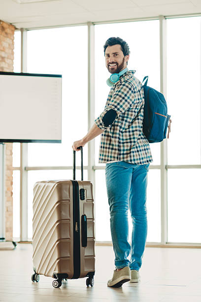 istock Confident traveler with luggage and backpack ready for an adventure at a bright modern airport terminal 2232057671