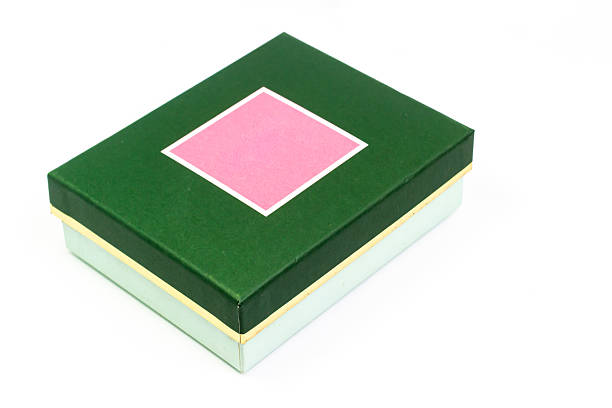A neatly presented green gift box is centered on a white surface, adorned with a pink diamond shape, creating a vibrant and elegant impression perfect for various celebrations