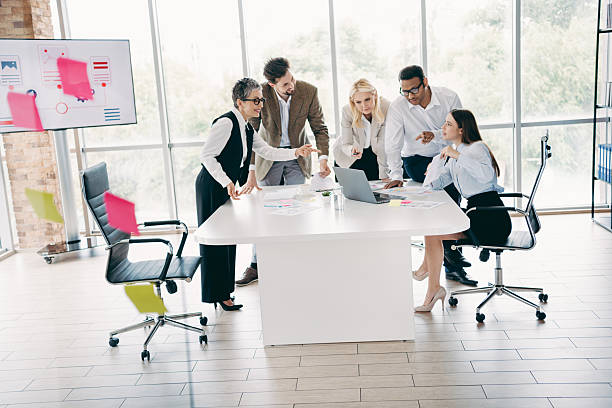 istock Team meeting in a modern office with colleagues collaborating on a project around a table showcasing teamwork and innovation 2232058852