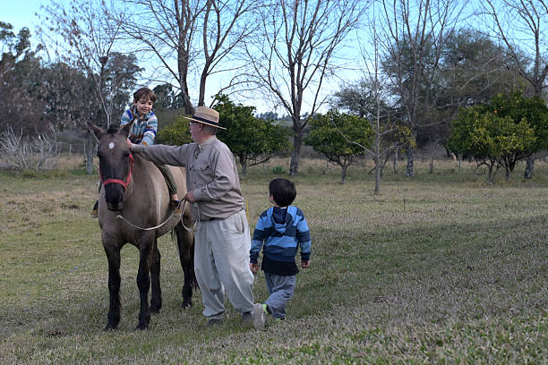 grandfather taking his nephews for a ride on horseback in the countryside