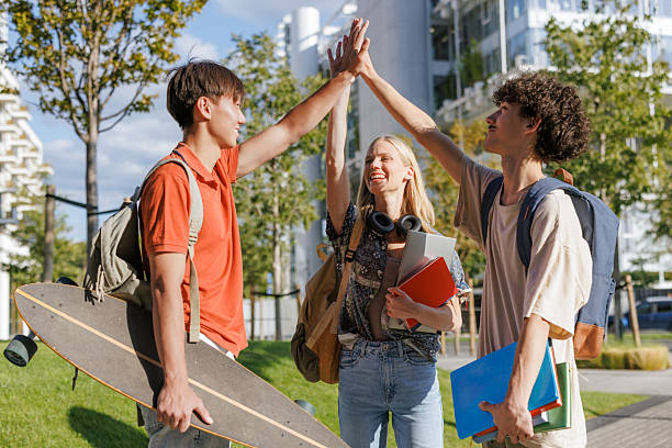 Group of friends celebrating with high fives outdoors, showcasing energy, friendship, and camaraderie.